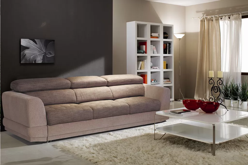 Комфортна вітальня з м’яким диваном у теплих тонах і мінімалістичними деталями інтер’єру