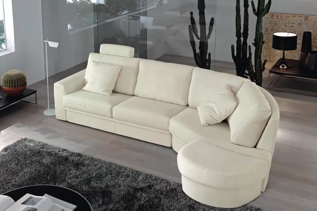 Елегантний бежевий кутовий диван з напівкруглим сидінням у просторій вітальні з кактусами та панорамними вікнами