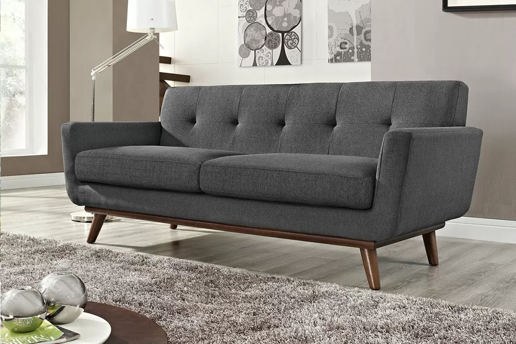 Лаконічний темно-сірий диван у мінімалістичному стилі з дерев’яною основою у світлій кімнаті